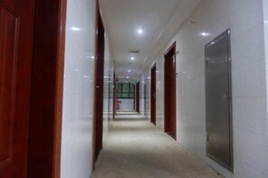 A corridor with doors on both sides, leading to rooms. - 8 Inn (Dongguan)