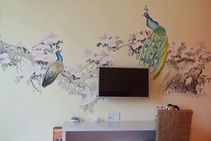 A wall-mounted television above a white counter with a woven basket and a box. - 8 Inn (Dongguan)