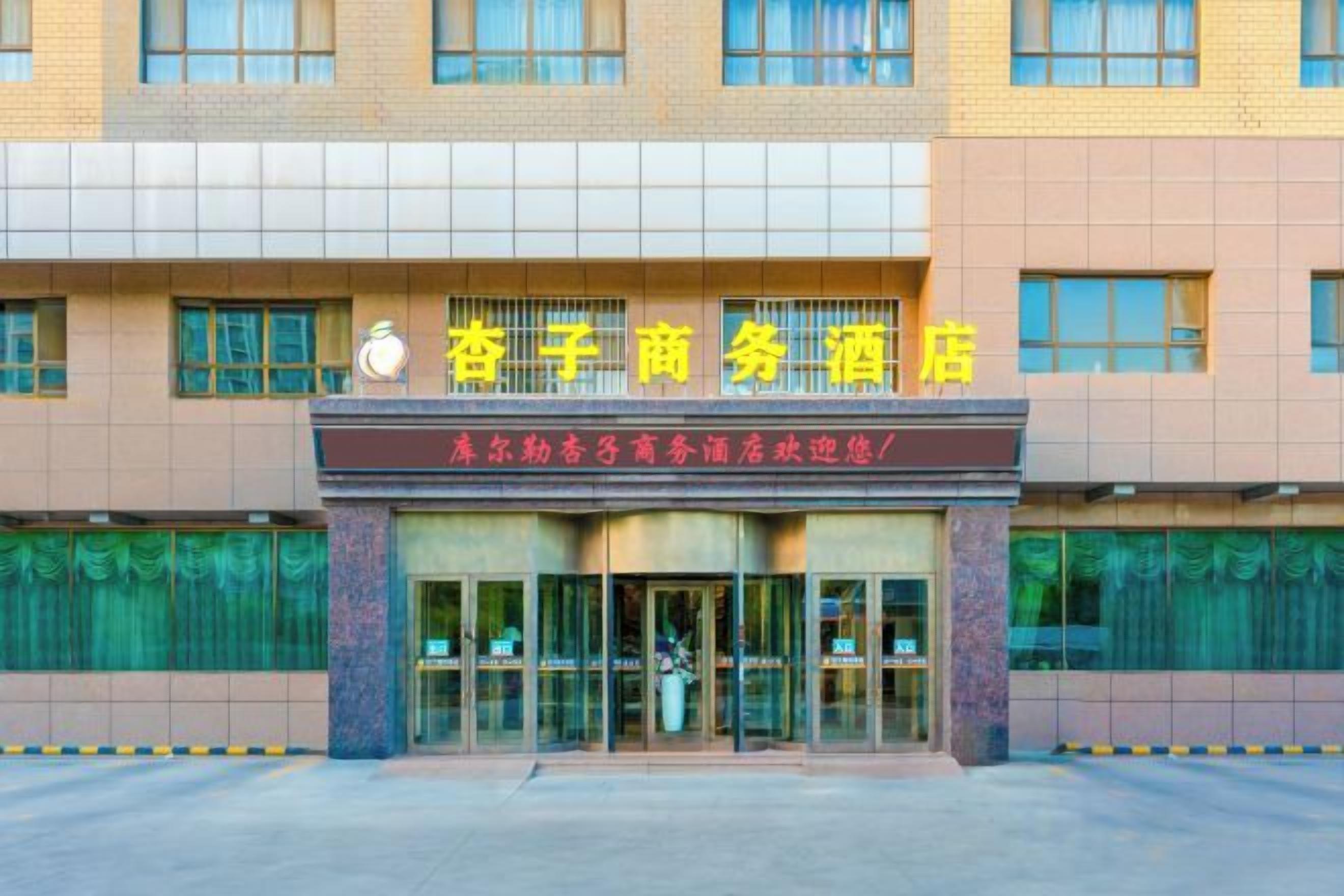 A hotel entrance with a sign above the doors.