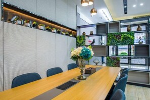 A conference room with a long table, chairs, and a decorative vase. - Ruyi Hotel (Foshan Nanhai Songgang Avenue) (Foshan)