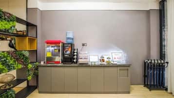 Uma área de recepção com balcão, máquina de café e dispensador de água.