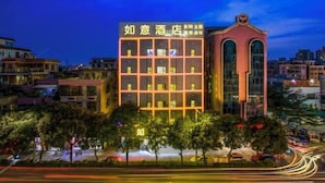 A hotel with a modern facade, multiple floors, and a prominent entrance with a decorative arch. - Ruyi Hotel (Foshan Nanhai Songgang Avenue) (Foshan)