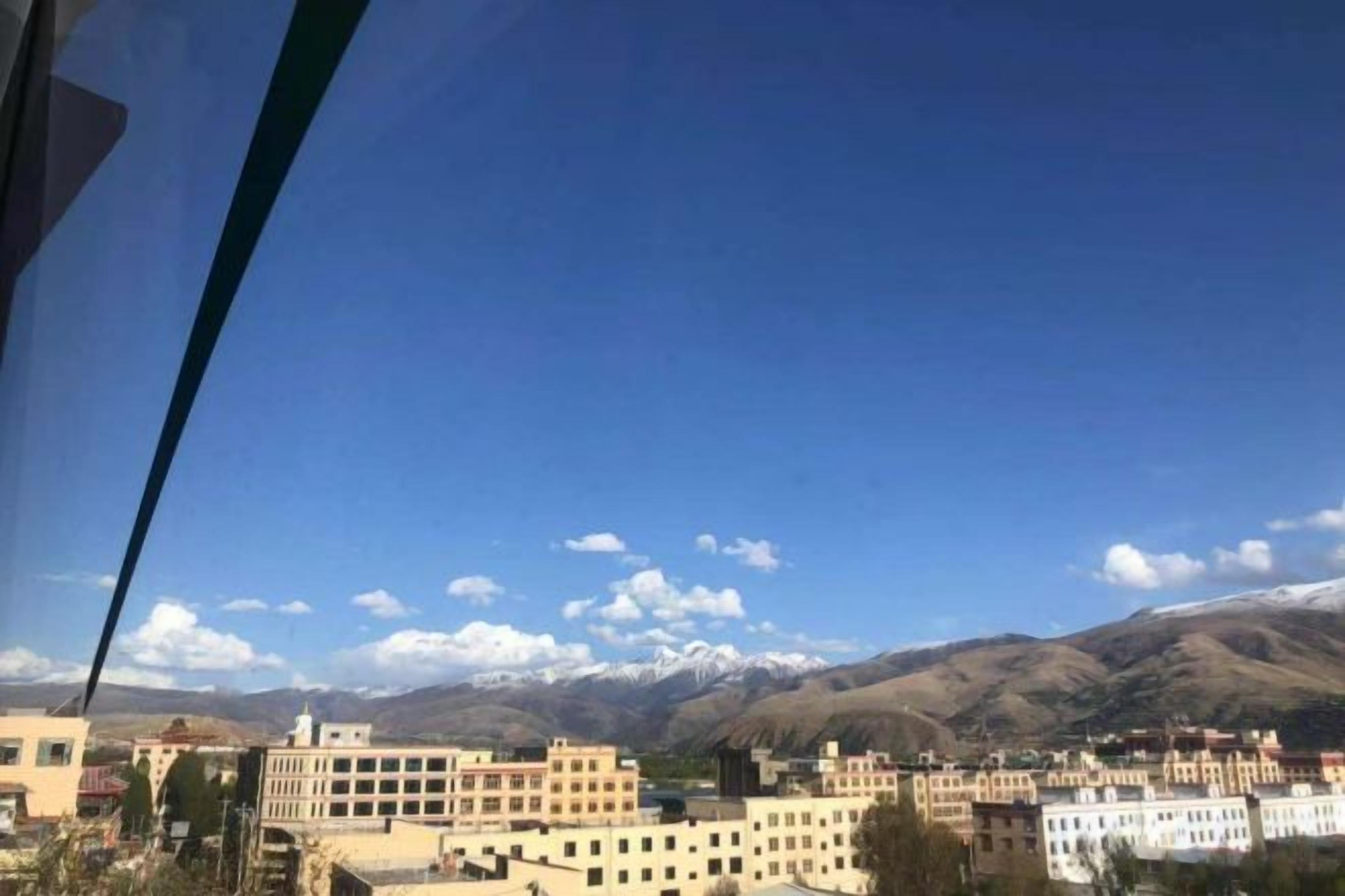 Vista de un pueblo con edificios y montañas al fondo.