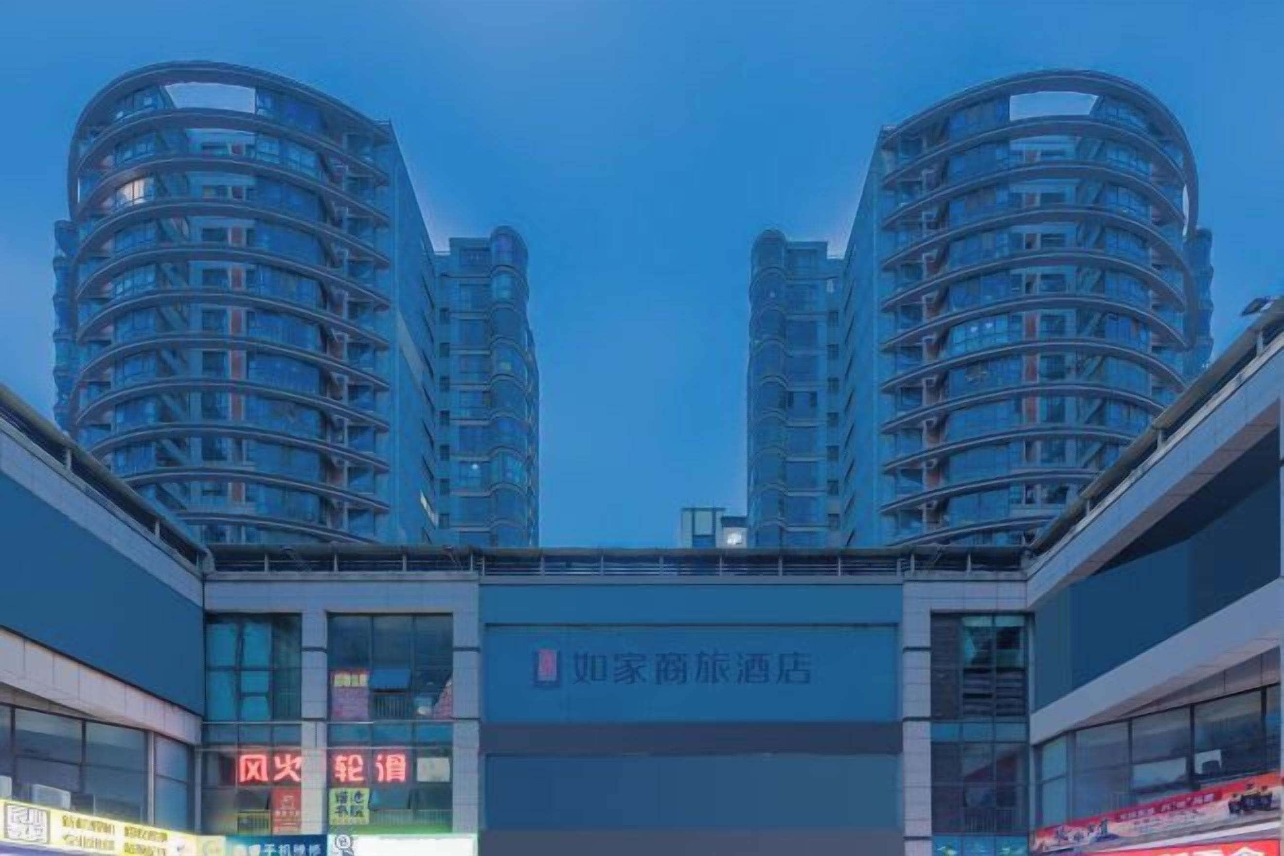 A modern building with two cylindrical towers and a horizontal structure in the foreground.