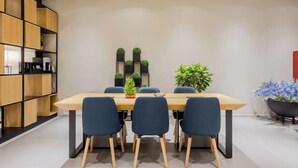 A modern dining area with a wooden table and chairs, surrounded by shelves and potted plants. - Homeinn Selected Hotel (Nanjing Xiongzhou Subway Station Jinning Plaza) (Nanjing)