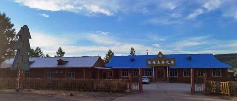 A building with a blue roof and a sign above the entrance.