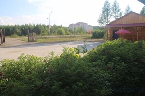 A paved area with a building and a red umbrella.