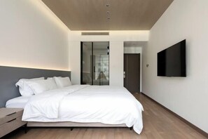 A modern bedroom with a large bed, a flat-screen TV mounted on the wall, and a sliding door closet. - Yunshang Zhulin Yaju · Swimming Pool Resort Minshuku (Anji)
