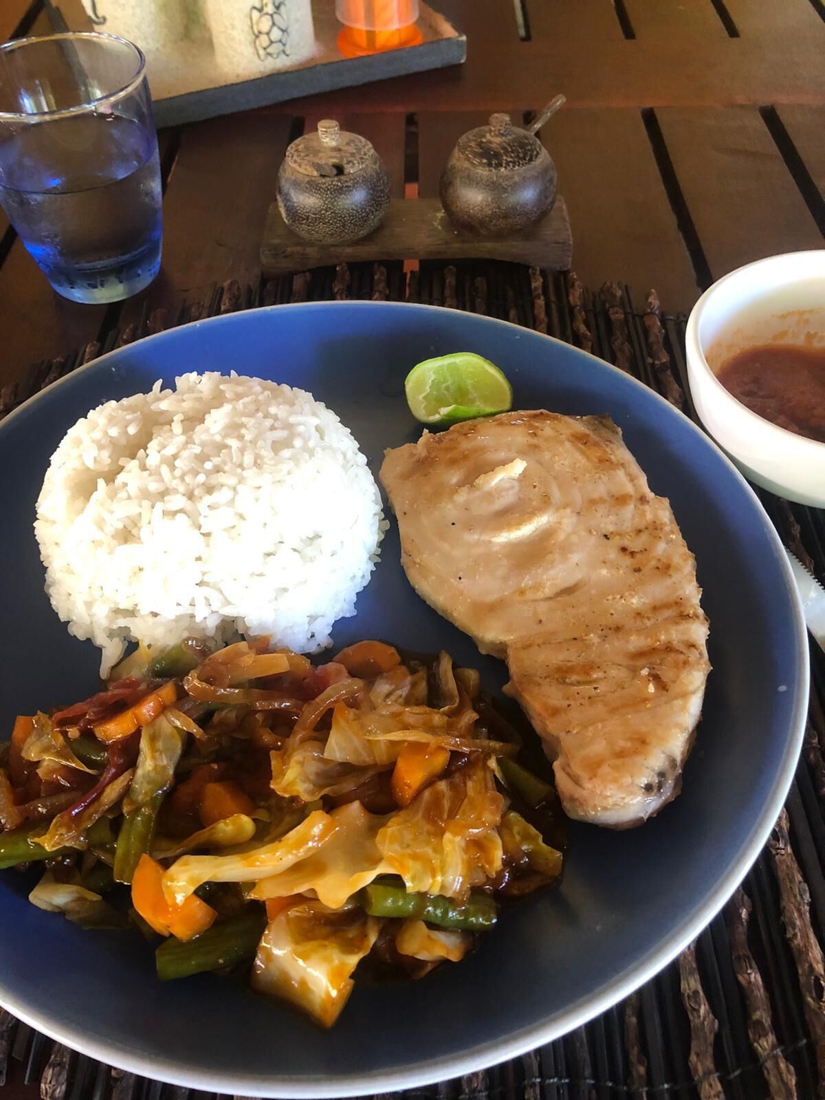 A plate with white rice, grilled chicken, and sautéed vegetables.
