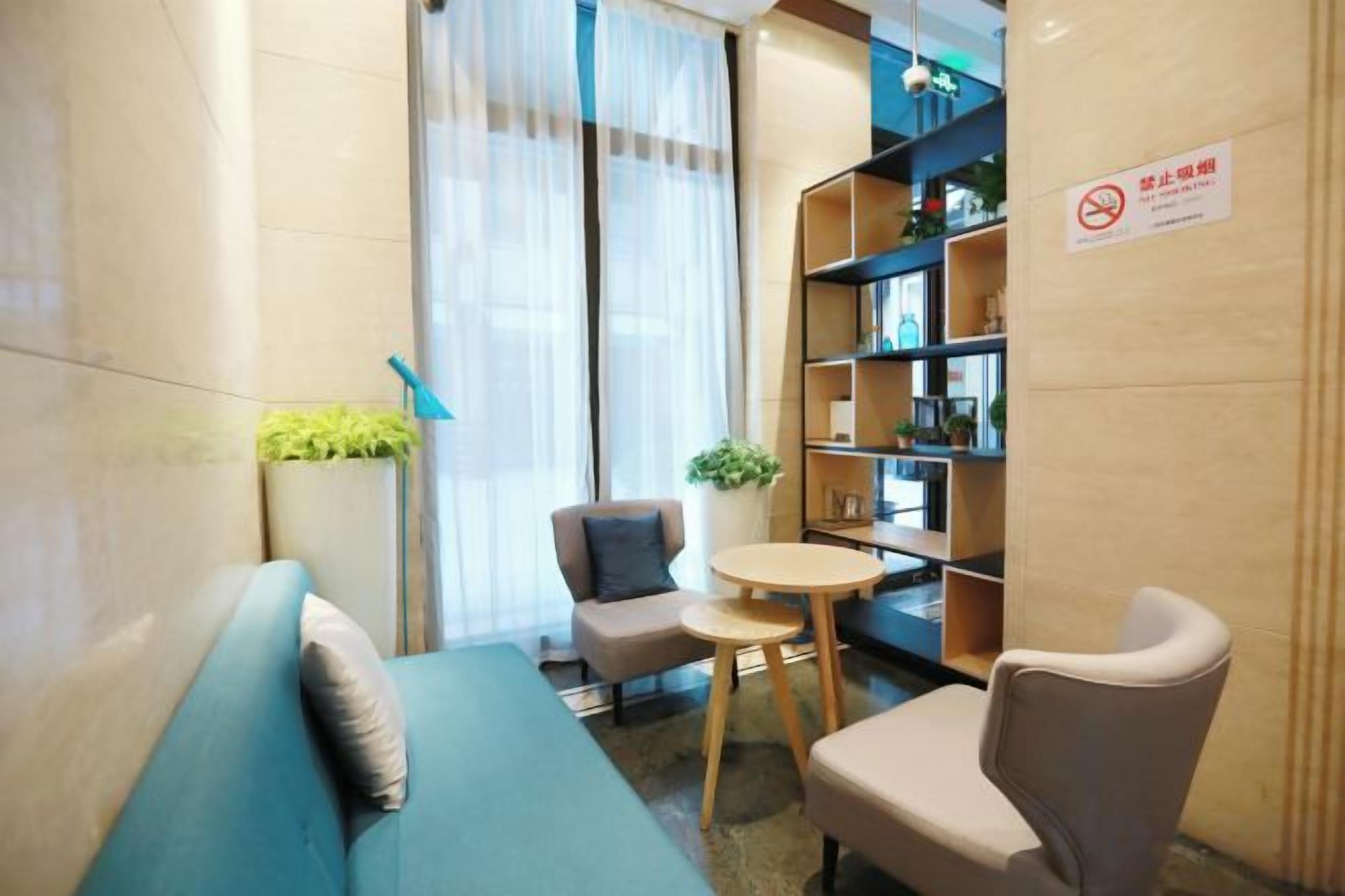 Una habitación moderna con sofá, una silla, una mesita y una estantería.