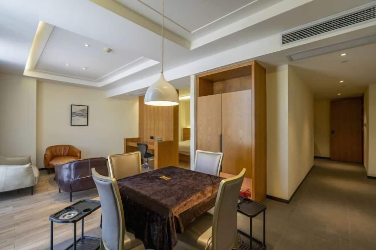 A modern dining area with a table, chairs, and a pendant light.