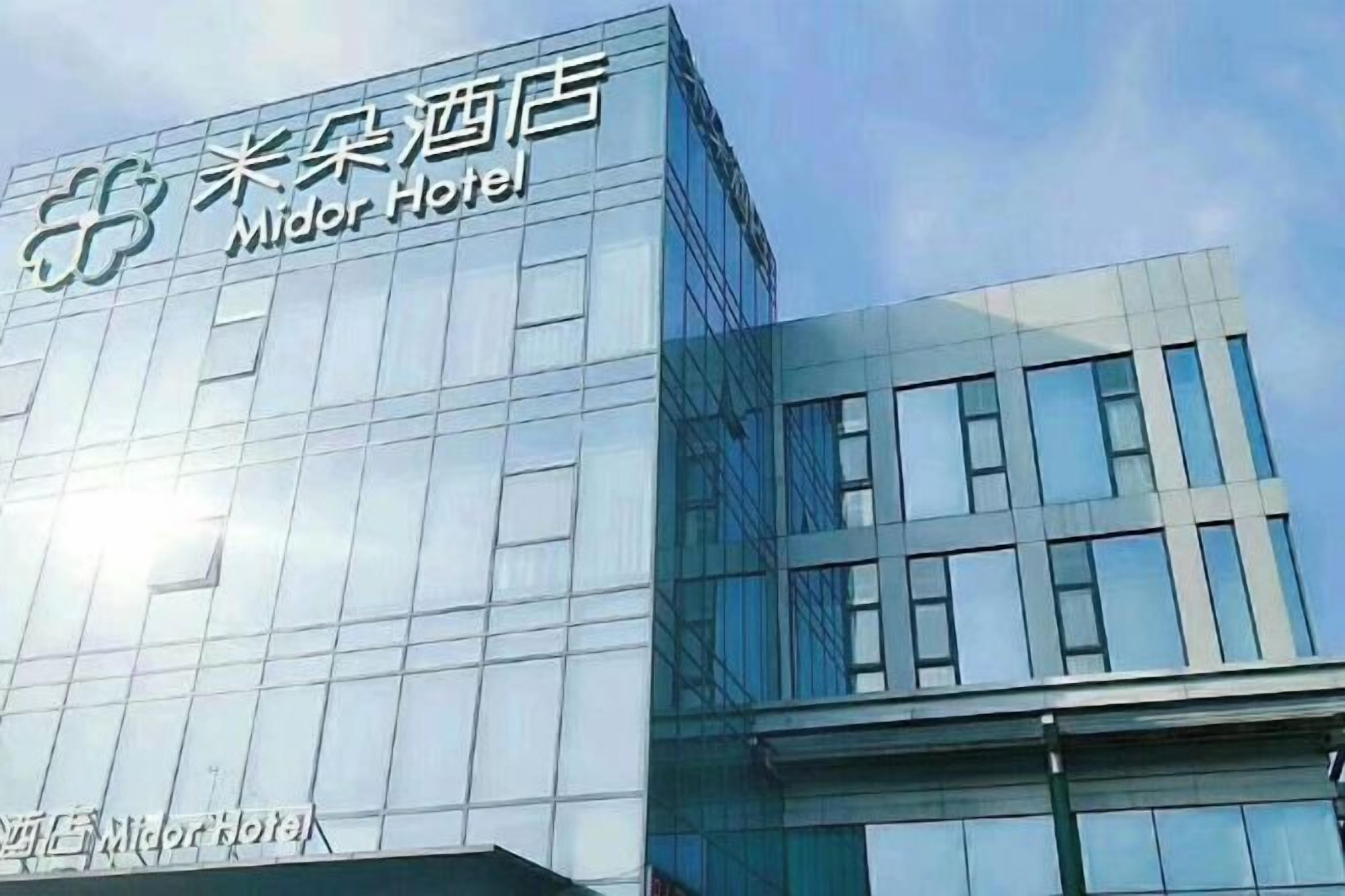 A modern hotel building with a clear sign reading 'Midor Hotel'.