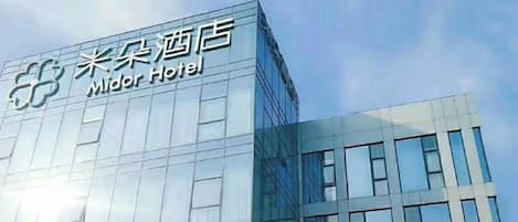 A modern hotel building with a clear sign reading 'Midor Hotel'.