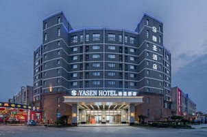 Un hotel de varios pisos con diseño moderno, que destaca por su entrada y señalización.