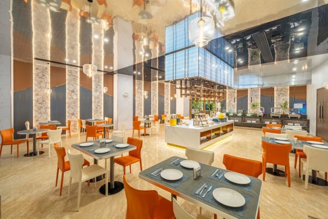 A spacious restaurant with high ceilings, modern lighting, and a central bar area.