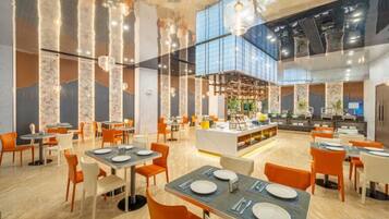 A spacious restaurant with high ceilings, modern lighting, and a central bar area.