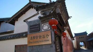 A traditional building with a sign indicating it is the Shexi Guzong Horse House.