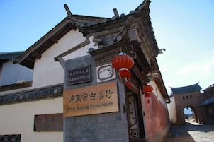 Un edificio tradicional con un letrero que indica que es la Casa de Caballos Shexi Guzong.