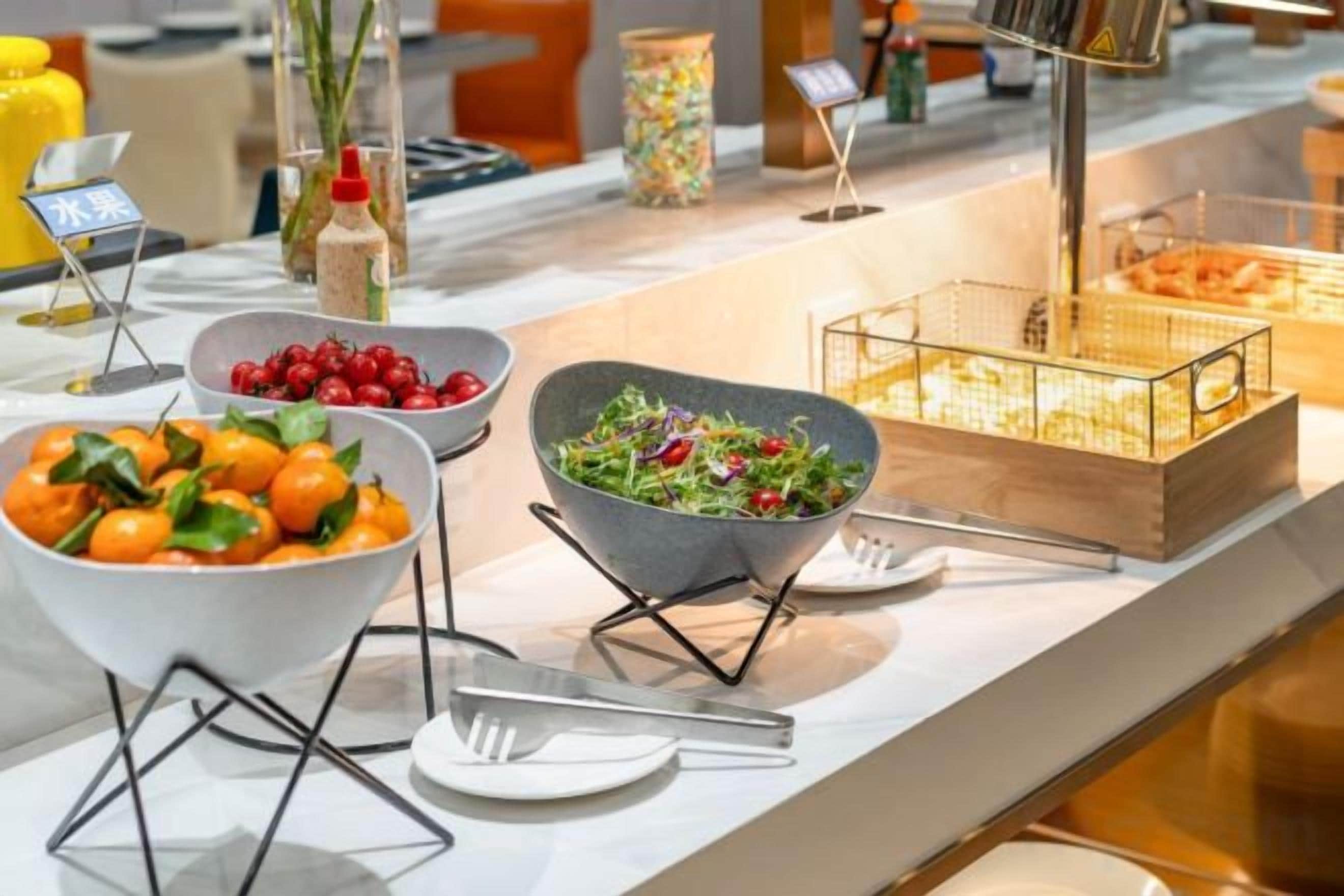 Disposição de buffet com diversos alimentos e utensílios.