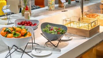 Disposição de buffet com diversos alimentos e utensílios.