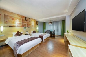 A hotel room with two beds, a desk, a chair, a TV, and a large window with curtains.
