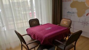A room with a table and four chairs, a small table with a bowl, and a map on the wall. - NO.1 Youke Hotel(Dongguan Shebei store) (Dongguan)