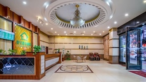 A hotel reception area with a modern design, including a reception desk, seating area, and a chandelier. - NO.1 Youke Hotel(Dongguan Shebei store) (Dongguan)