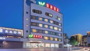 A multi-story hotel with a prominent sign indicating it is a wellness hotel. - WeiKang Hotel JiShouDaXueDian (Zhangjiajie)