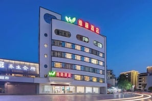 Een meerhoog hotel met een opvallend bord waarop staat dat het een wellnesshotel is.
