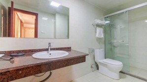 A bathroom with a granite countertop, a white sink, a mirror, a toilet, and a glass shower enclosure. - Fangshun Hostel Chongming (Shanghai)