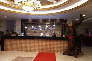 A reception area with a counter, a chandelier, and a decorative tree sculpture. - Fangshun Hostel Chongming (Shanghai)