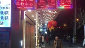 A corridor with illuminated signs and a red lantern, indicating a commercial area with shops. - Fangshun Hostel Chongming (Shanghai)