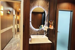 Un baño moderno con un espejo grande, un lavabo y un mueble de tocador con espejo.