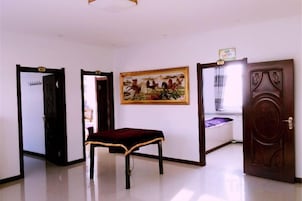 Una habitación con un banco, una puerta y un cuadro en la pared.