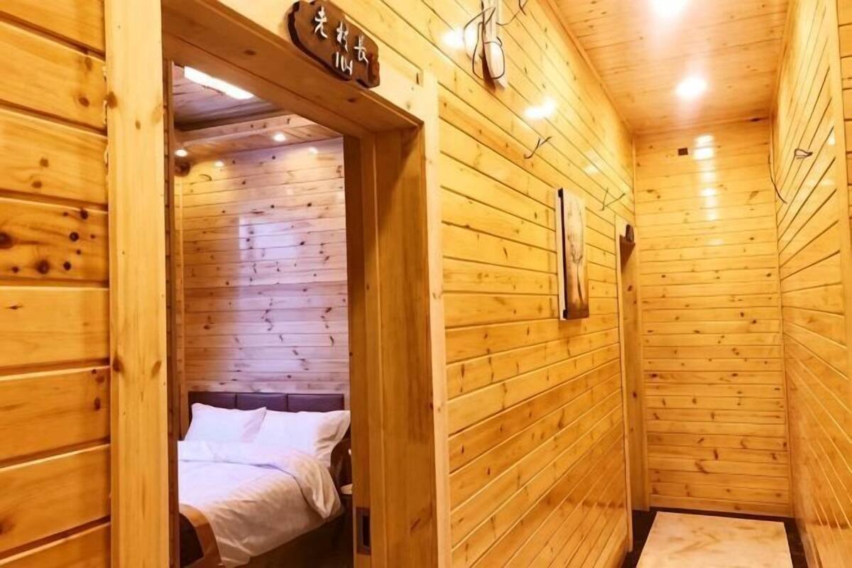 Ein Holzinnenraum mit einem Bett, einer Holztür und einem Schild darüber.
