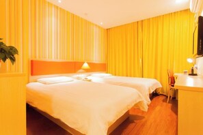 Une chambre d’hôtel avec deux lits, un bureau et une chaise.