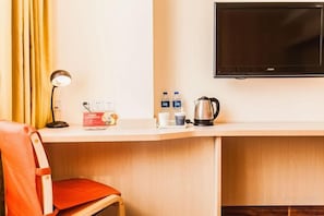 A hotel room with a desk, a chair, a television, a lamp, and a coffee maker. - Home Inn (Taiyuan Jinci Road Jinyang Lake Park) (Taiyuan)