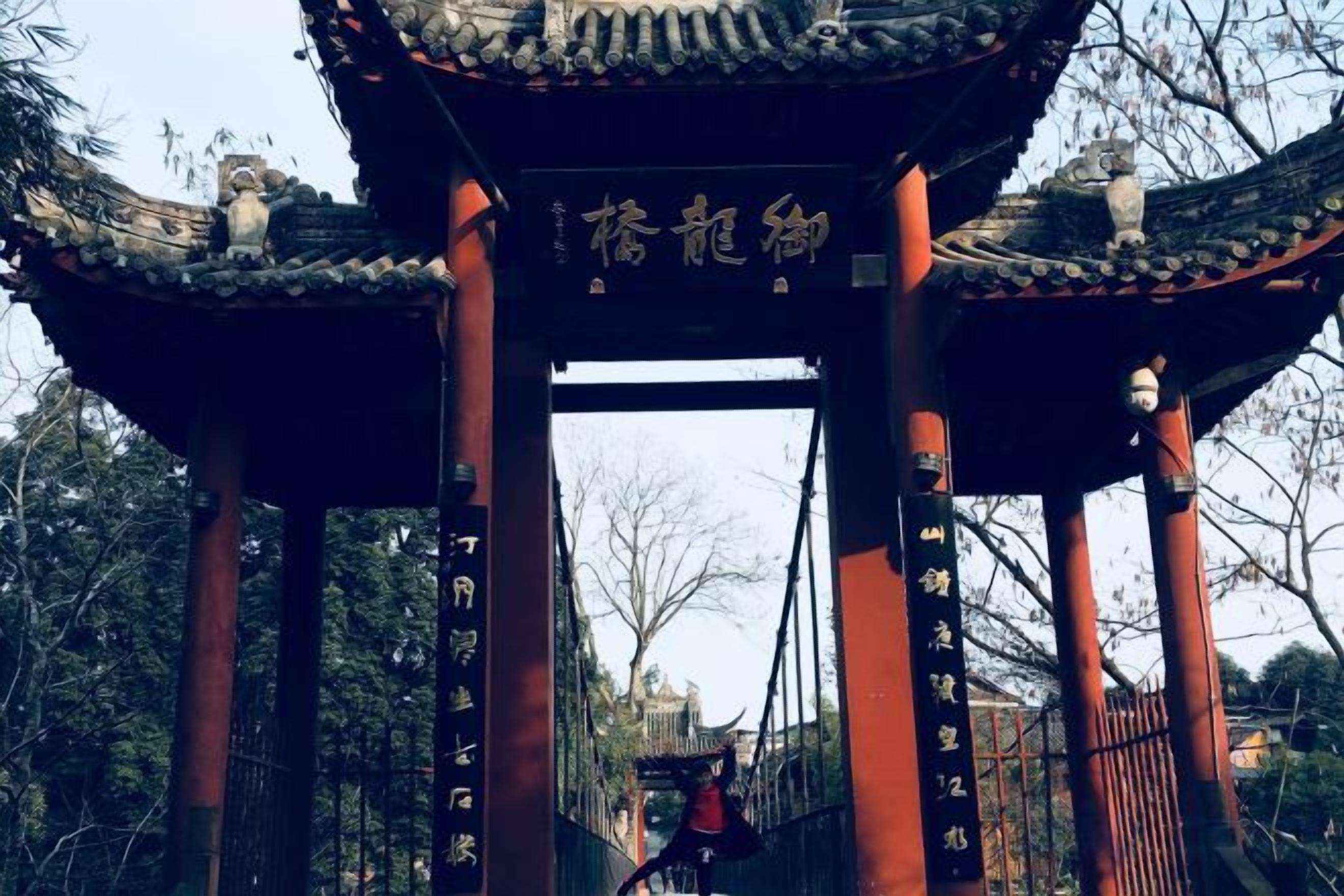 A traditional Chinese gate with inscriptions, leading to a pathway.