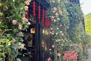 A traditional building with a garden entrance featuring climbing roses and red lanterns. - Jiezi Ancient Town Old Manor (Chongzhou)