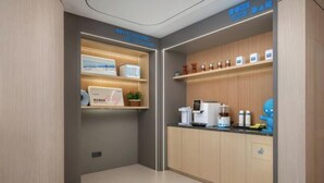 A modern kitchen with wooden cabinets, a coffee machine, and a small plant.