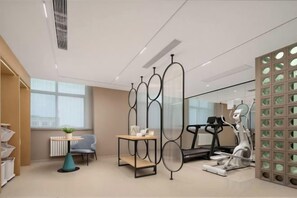 A modern room with a treadmill, a desk, and a chair.