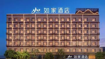 A multi-story hotel building with a uniform facade, multiple windows per floor, and a prominent hotel sign at the top.