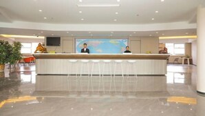 Un área de recepción moderna con un mostrador central, taburetes tipo bar y un gran mapa del mundo en la pared.