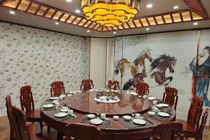 Un salón de conferencias con una mesa redonda, sillas y un mural de caballos en la pared.