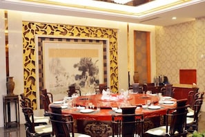 A conference room with a round table set for a meeting, surrounded by chairs.