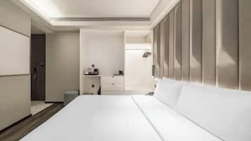 Une chambre d’hôtel avec un grand lit, un bureau, une coiffeuse et un espace douche.