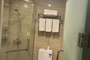 A shower area with a glass door, a towel rack with folded towels, and a water heater. - Kaiwang Hotel (Nanjing Mingguo Subway Station Military General Hospital) (Nanjing)