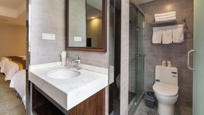 Un bagno moderno con doppio lavabo, un grande specchio, cabina doccia in vetro e water.
