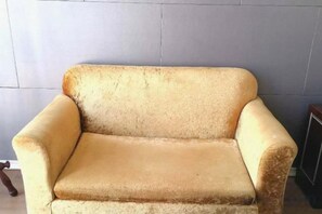 A vintage armchair with a high backrest and armrests, positioned against a plain wall. - Landing International Hotel (Dianjiang County)