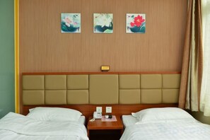 A hotel room with two beds, a wooden headboard, and three floral wall art pieces. - Kangyuan Express Hotel Beijing (Beijing)